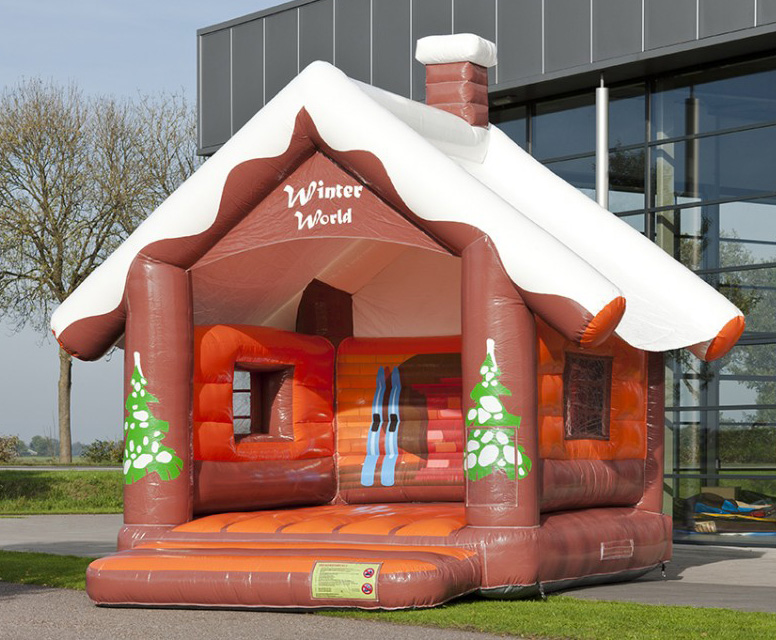 Hüpfburg als verschneite Berghütte mit Schornstein und Tannenmotiv