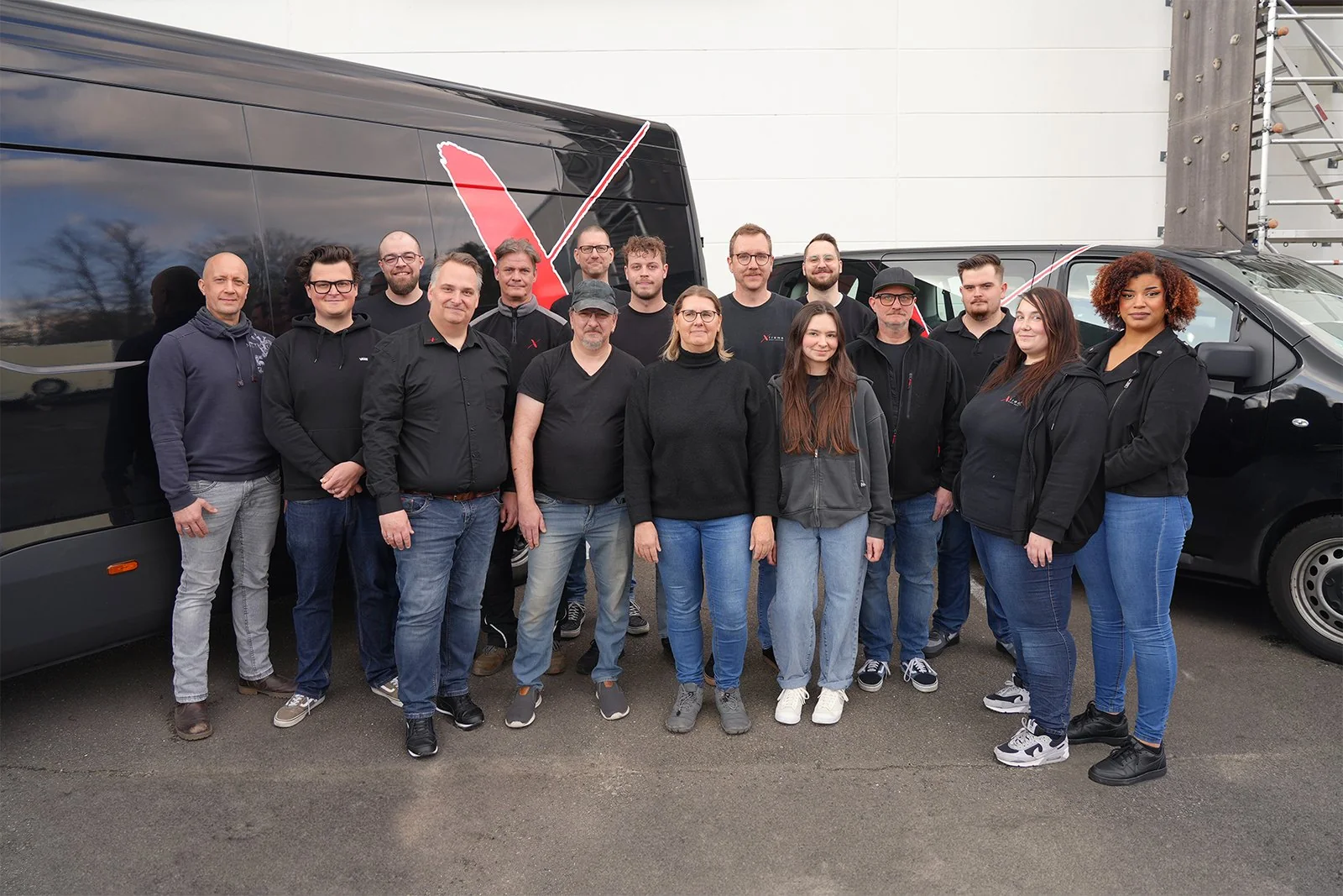 Das Xtreme-Team in schwarzen Shirts vor den Firmenfahrzeugen