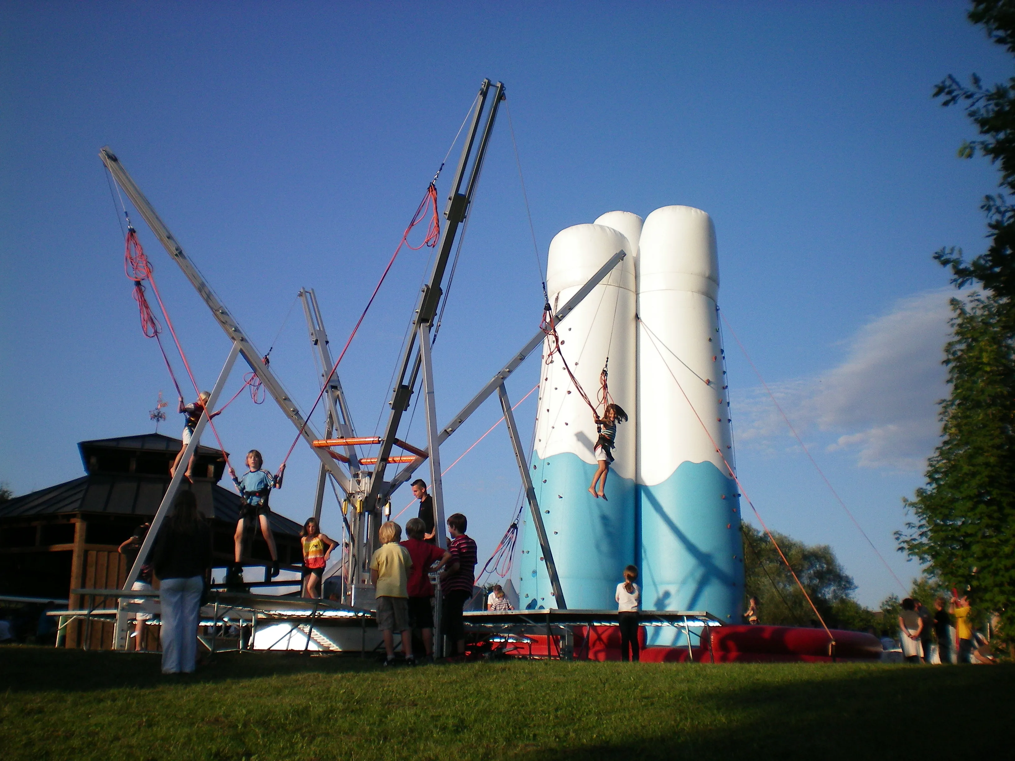 Bungee-Trampolin-Anlage und aufblasbare Attraktion am Abend auf einer Wiese