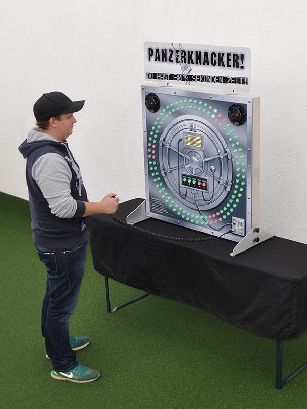 Teilnehmer bedient das Tresorspiel „Panzerknacker“ mit leuchtendem Zahlenring